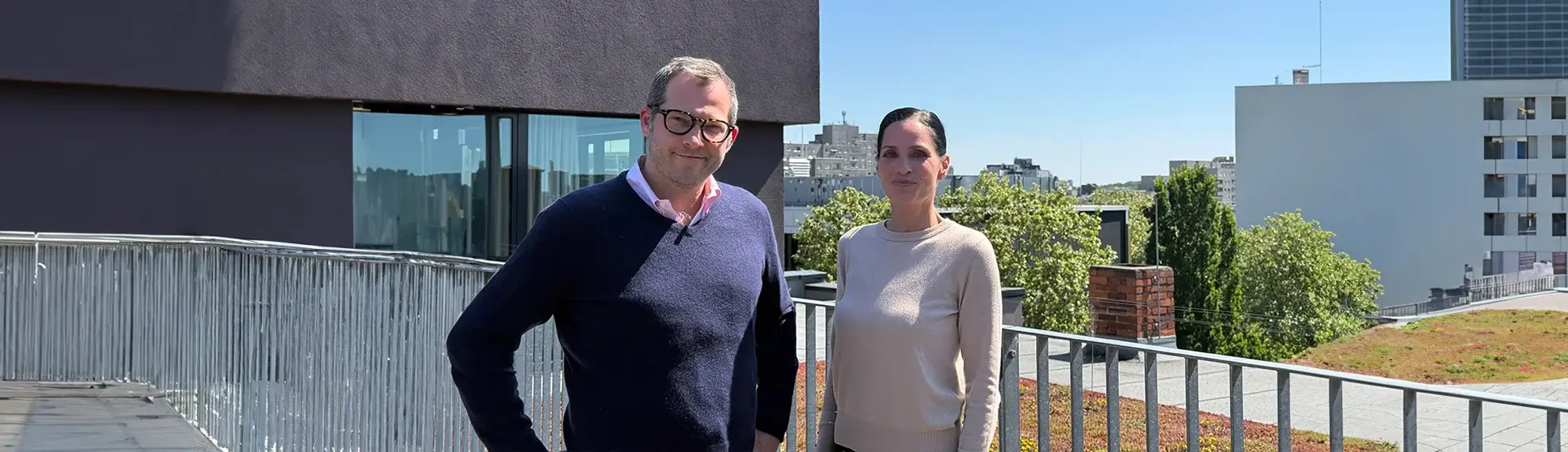 Julian Reichelt und Janina Schaefer auf einer Dachterrasse vor urbaner Kulisse